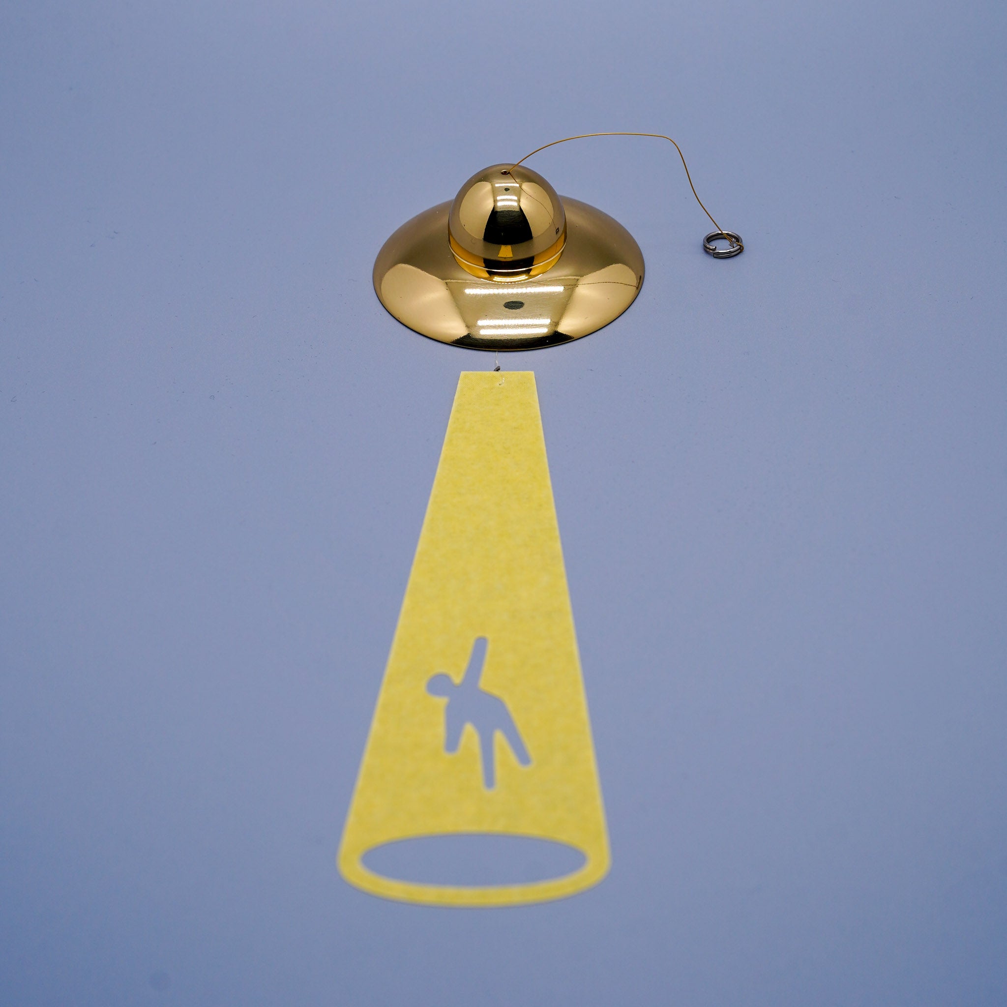 UFO disc-shaped brass wind chime in gold close-up showing cord and hanging mechanism, by Nousaku, Takaoka, Toyama, Japan