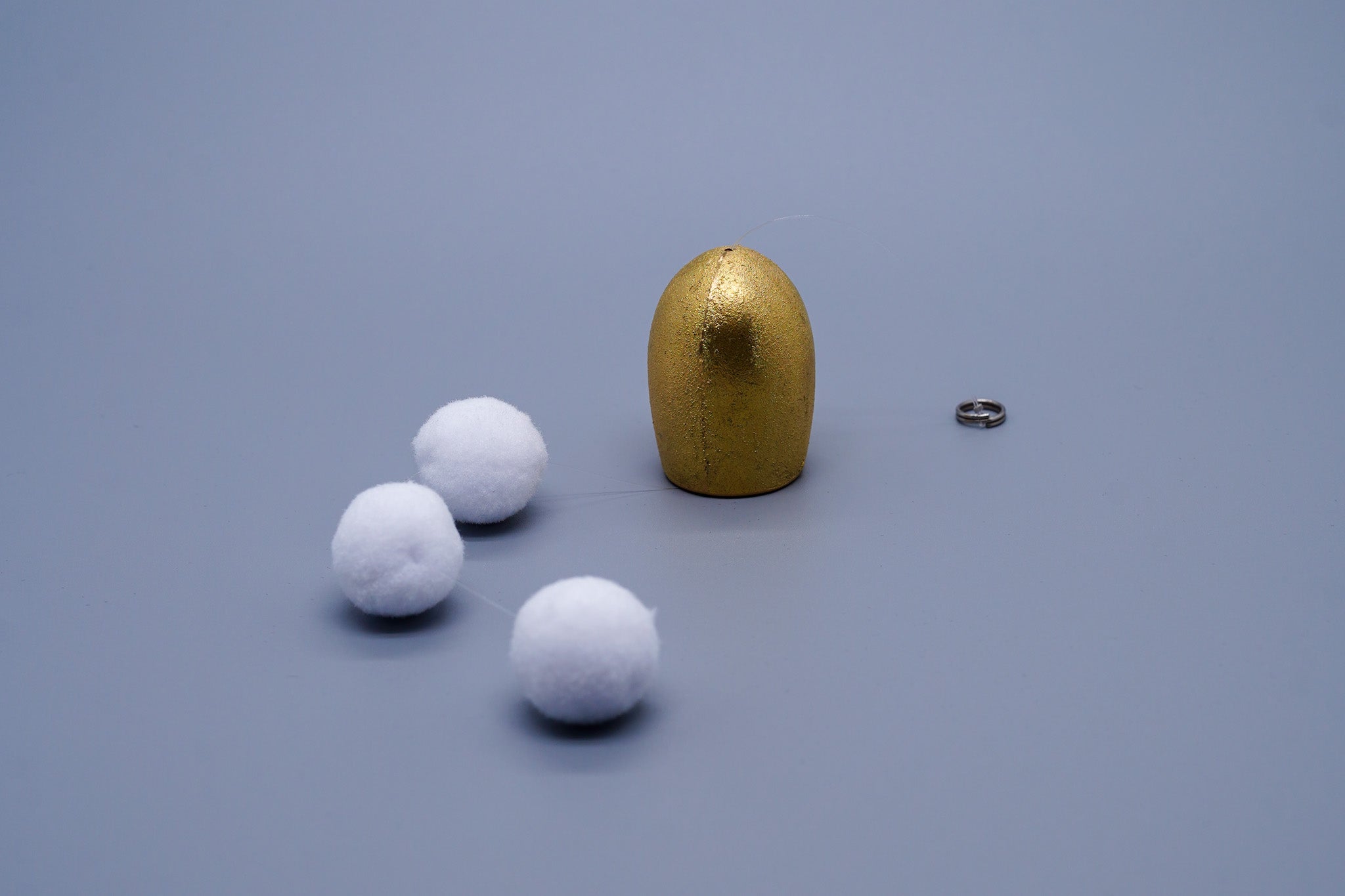 Tsubomi brass wind chime in gold with components laid flat including cotton ball clappers and cord ring, by Nousaku, Japan