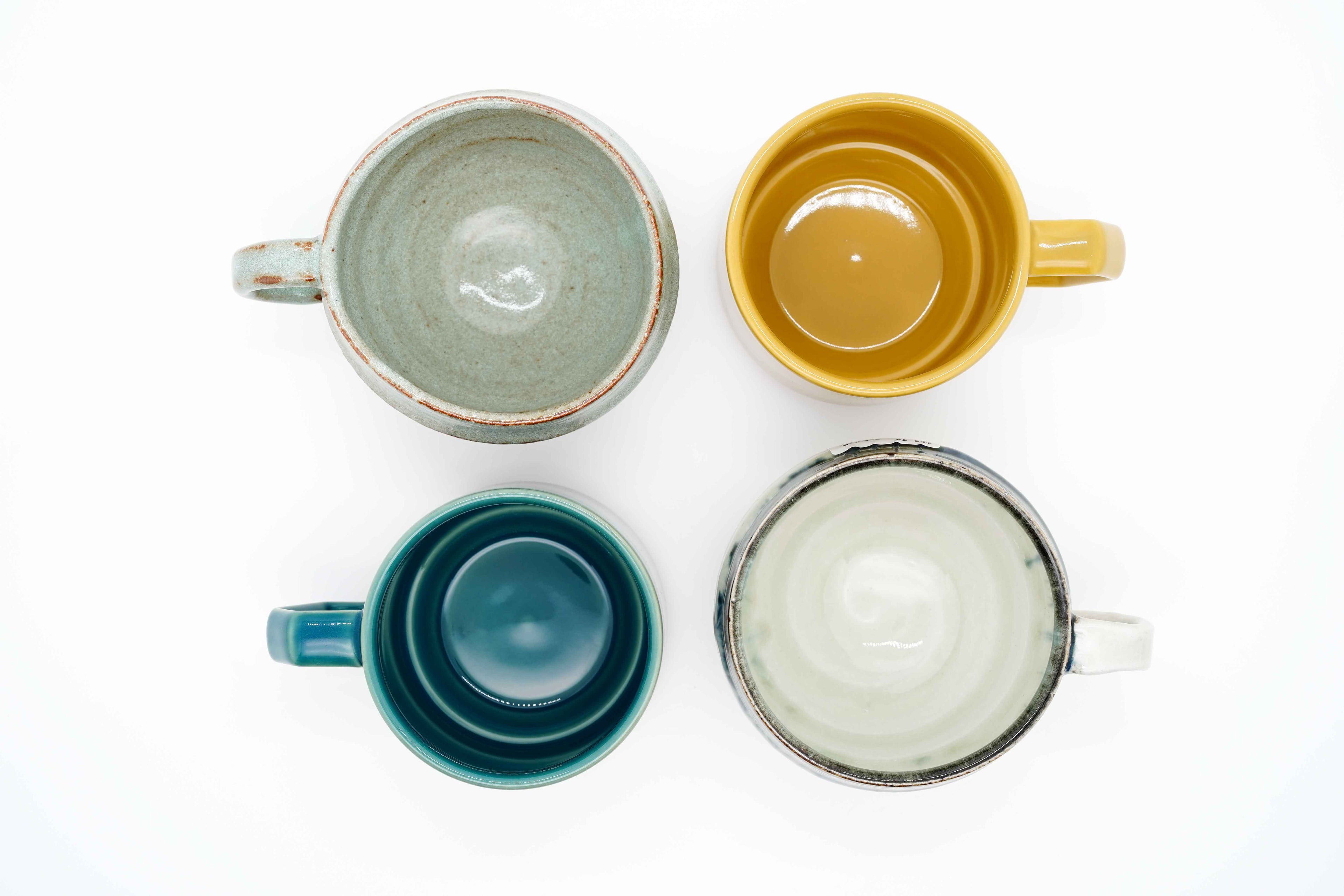 Four Mino-yaki ceramic mugs — CHIPS stackable mugs in green and yellow, Nagara Drops in teal and Aigetsu Shiro in white, made in Japan