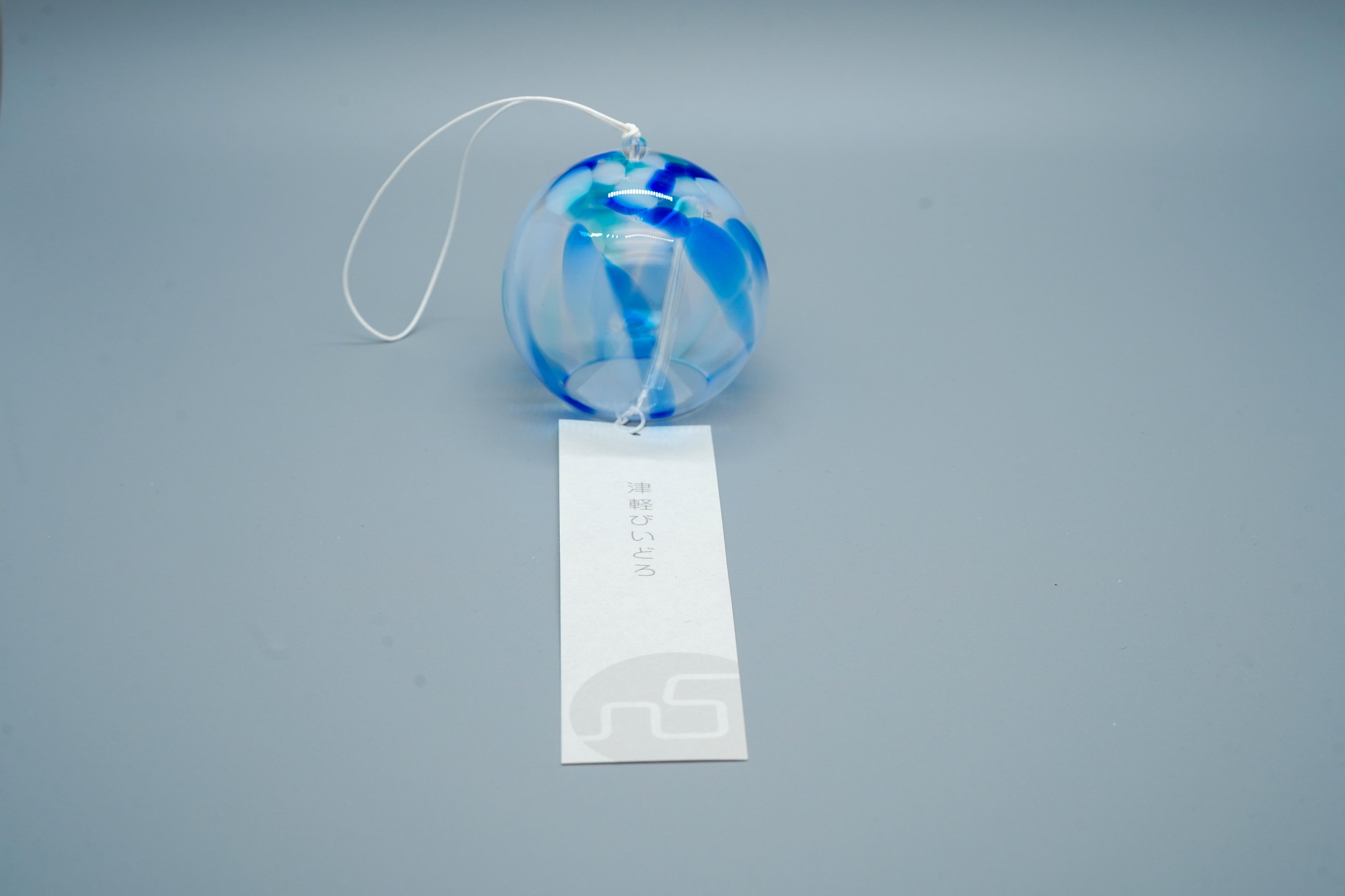 Adelia hand-blown glass wind chime in blue close-up showing swirling glass pattern and cord, by Tsugaruvidro, Aomori, Japan