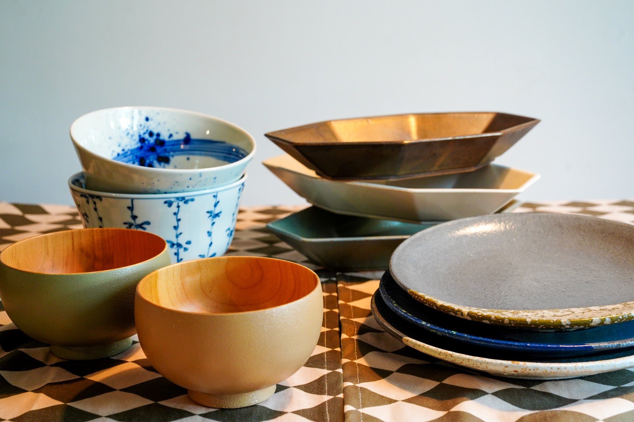 Collection of made in Japan, ceramic bowls and plates on a checkered tablecloth