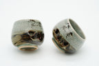 Two tilted Soma sake cups showing running horses, crackled glaze and heart-shaped openings.