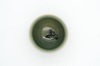 Overhead view into the Soma Eight Horses cup showing its green interior and a black calligraphic character at the bottom.