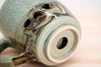 Close-up of the Soma mug’s recessed base with a circular opening, pale foot ring and heart-shaped cutouts above.