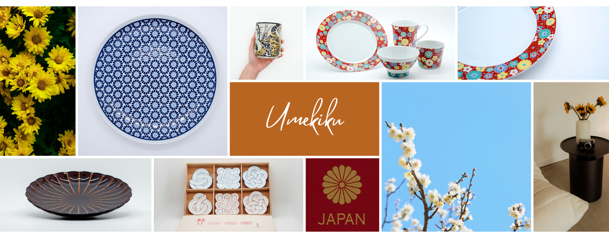 A collage of Japanese tableware and decor items with Umekiku patterned plates, cups, a bowl, a box of white flower-shaped sweets, a dark patterned plate, chrysanthemum, plum and a small vase on a table. 