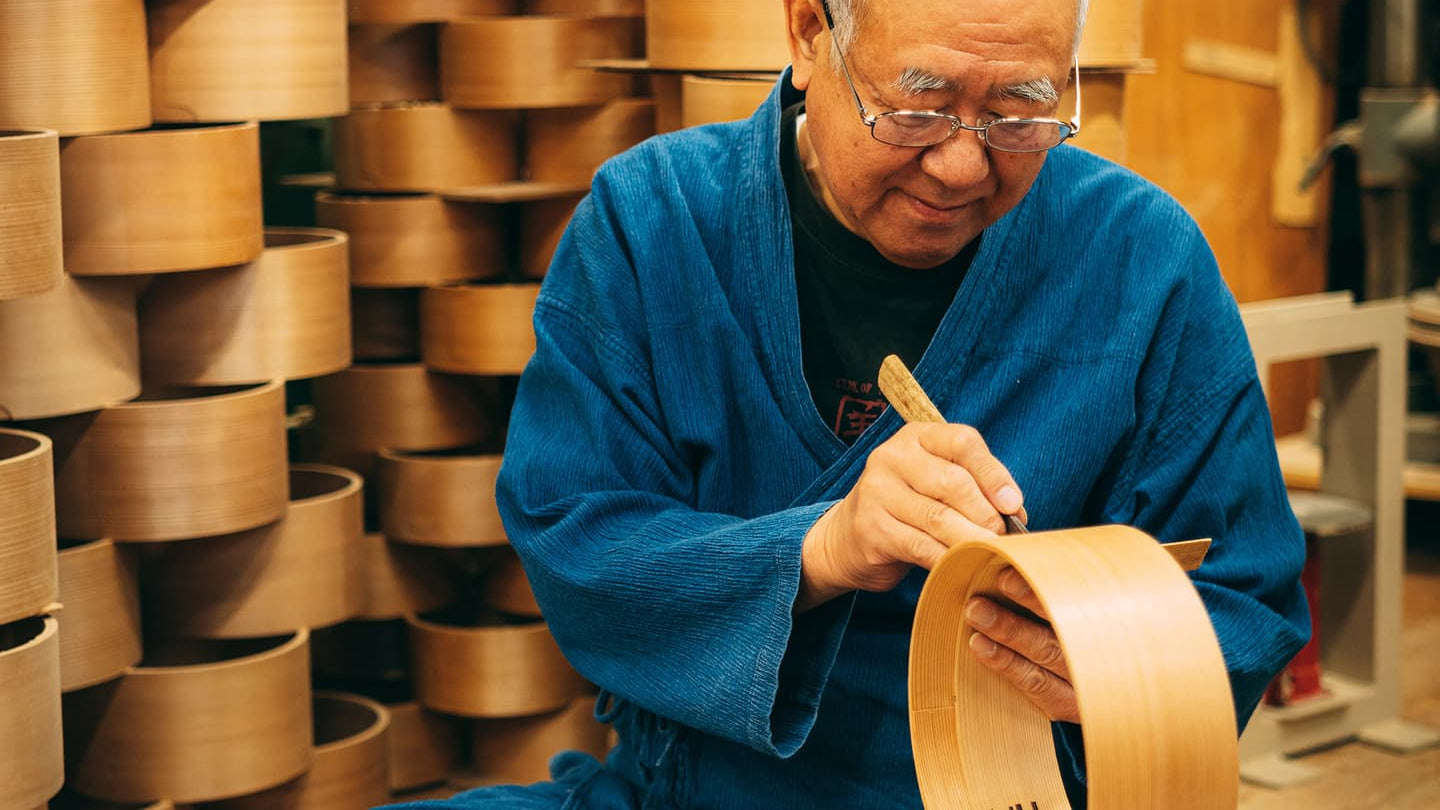 Kurikyu master working with bentwood bowls in a workshop.