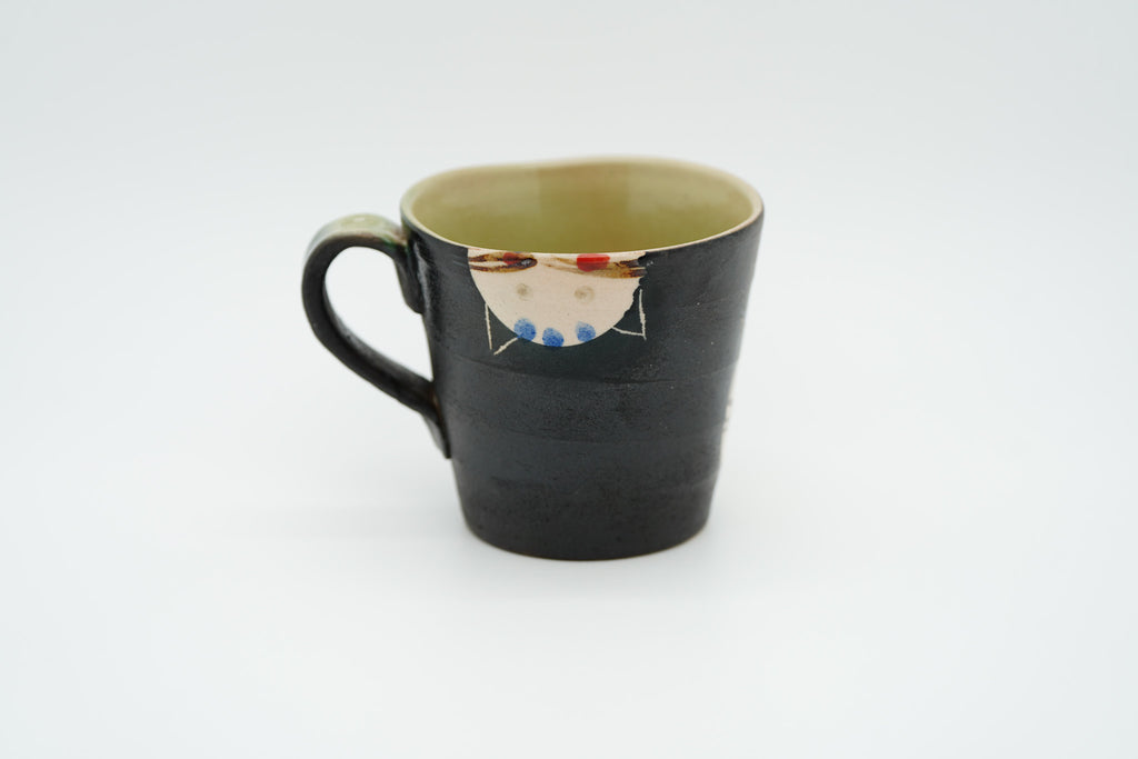 Reverse of the black Couple Cats mug showing an upside-down cream cat face just below the rim.