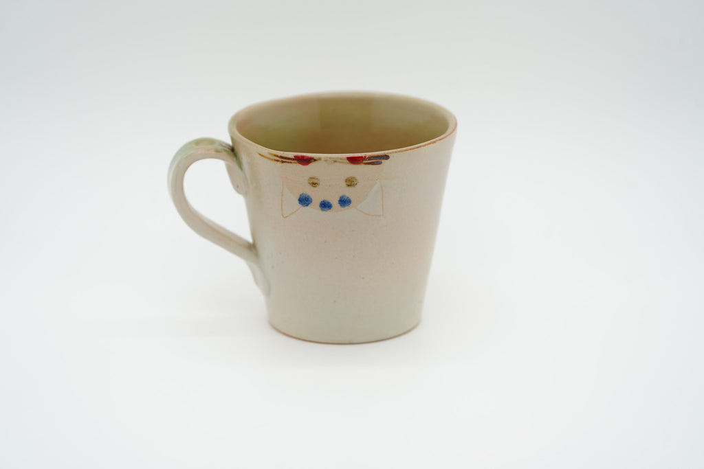 Reverse of the cream Couple Cats mug showing an upside-down cat face just below the rim.